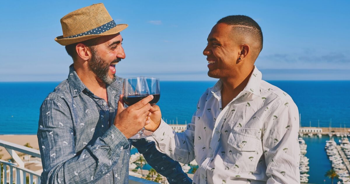 An,Interracial,Gay,Couple,Drinking,Wine,In,Front,Of,The An,Interracial,Gay,Couple,Drinking,Wine,In,Front,Of,The
