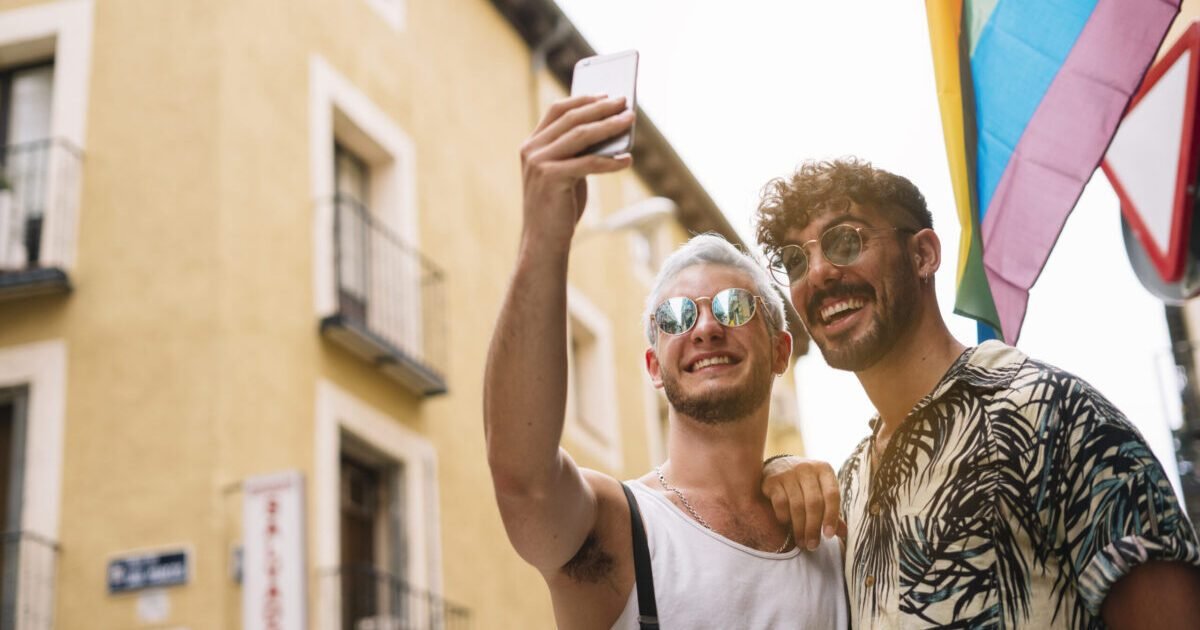 Gay couple of boys with Smatphone in the city of Madrid