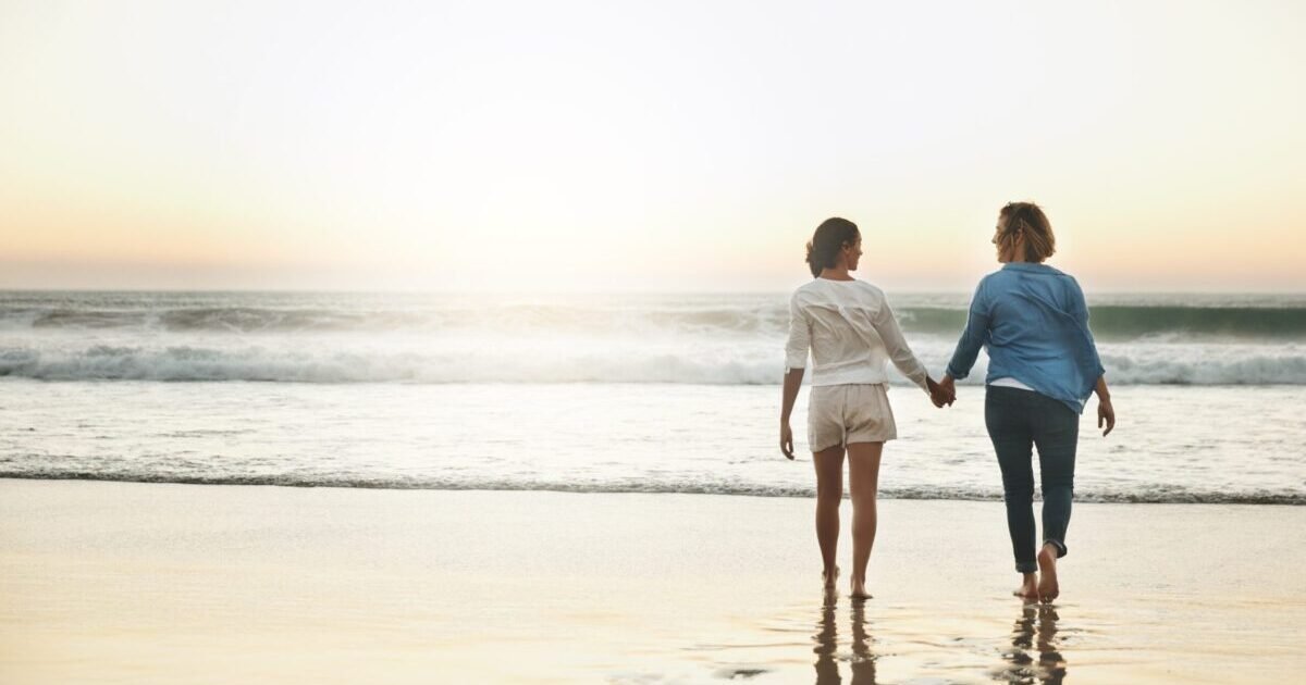Back,,Couple,And,Walking,In,Water,,Lesbian,And,Holding,Hands