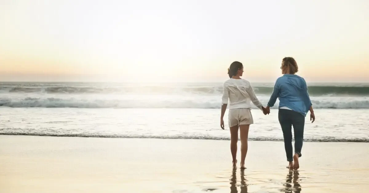 Back,,Couple,And,Walking,In,Water,,Lesbian,And,Holding,Hands
