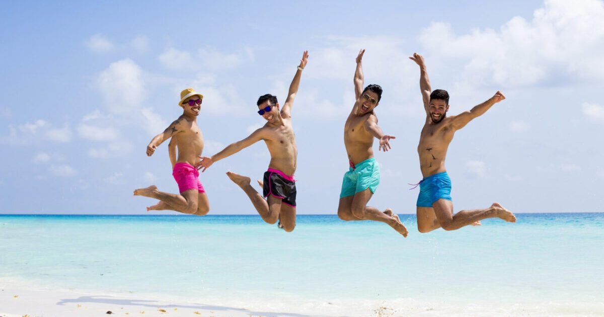 Group,Of,Four,Men,Jumping,At,The,Beach